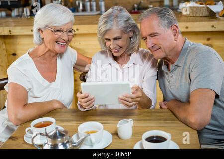 Gruppe von Senioren Freunde mit digital-Tablette in CafÃƒÂ © Stockfoto