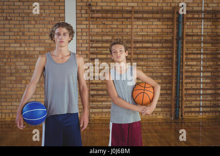 Porträt von zuversichtlich High-School-jungen Basketball in das Gericht halten Stockfoto