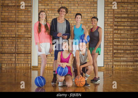 Porträt von High-School-Kids mit Basketball zusammenstehen in Basketballplatz Stockfoto
