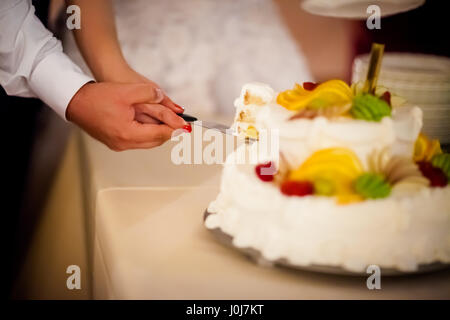 Wunderschöne Hochzeitstorte Detail. Traditionelle erste Scheibe Schneiden von Braut und Bräutigam Stockfoto