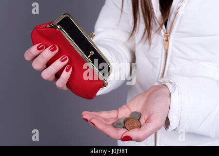 Frau mit einem in der Nähe von leeren Geldbeutel mit ein wenig Geld in der hand Stockfoto