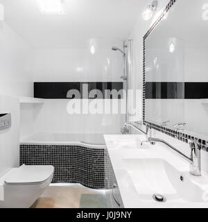 Elegantes Badezimmer Interieur mit modernen schwarzen Mosaik Akzente und großen Spiegel Stockfoto