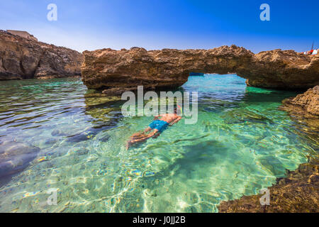 Blaue Lagune, Malta - Schnorcheln Tourist in den Höhlen der blauen Lagune auf der Insel Comino auf einem strahlend sonnigen Sommertag mit blauem Himmel Stockfoto