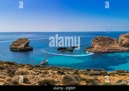 Comino, Malta - Panorama Skyline-Blick von der berühmten und schönen blauen Lagune auf der Insel Comino mit traditionellen Luzzu Boote, Segelboote und tou Stockfoto