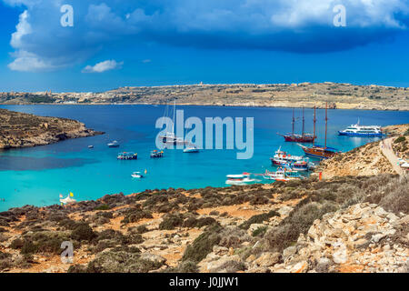 Comino, Malta - Panorama Skyline-Blick von der berühmten und schönen blauen Lagune auf der Insel Comino mit traditionellen Luzzu Boote, Segelboote und tou Stockfoto