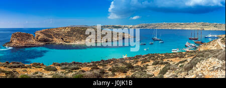 Comino, Malta - Panorama Skyline-Blick von der berühmten und schönen blauen Lagune auf der Insel Comino mit traditionellen Luzzu Boote, Segelboote und tou Stockfoto