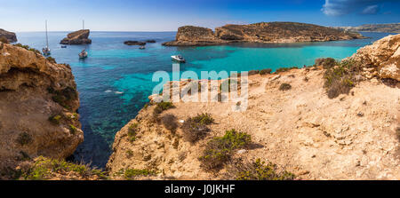 Comino, Malta - die schöne blaue Lagune mit Türkis klares Meerwasser, Yachten und Schnorcheln Touristen an einem sonnigen Sommertag mit der Insel Gozo Stockfoto