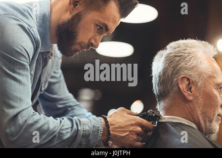 Charismatischen Barbier arbeiten am Arbeitsplatz Stockfoto