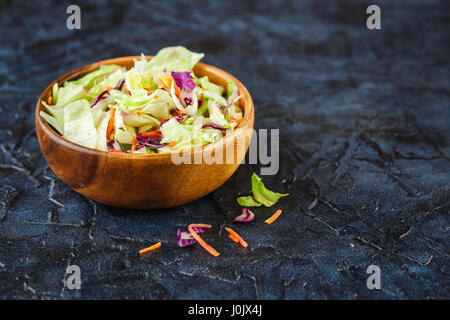 Hausgemachte vegetarische Salat in hölzerne Schale aus Eisbergsalat, Rotkohl und Möhren Stockfoto