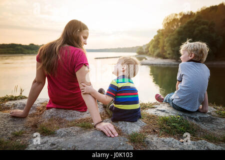 Mutter mit zwei Söhnen am See, sonnigen Frühlingstag. Stockfoto