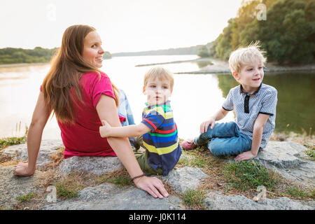 Mutter mit zwei Söhnen am See, sonnigen Frühlingstag. Stockfoto