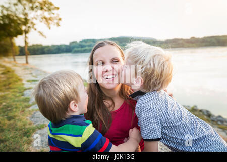 Mutter mit zwei Söhnen am See, sonnigen Frühlingstag. Stockfoto