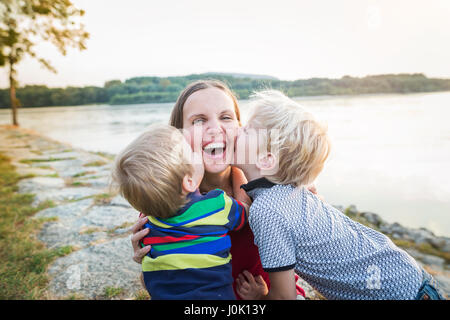 Mutter mit zwei Söhnen am See, sonnigen Frühlingstag. Stockfoto