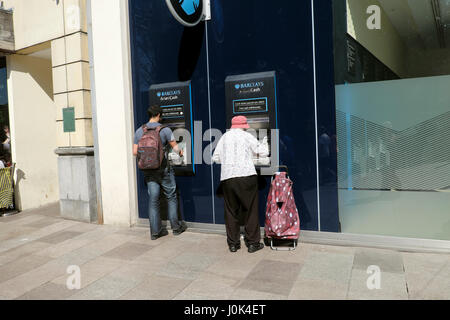 Ältere Frau mit Einkaufswagen immer Geld von Barclays Bank Geldautomaten in der Nähe von Hayes im Stadtzentrum von Cardiff, Wales UK KATHY DEWITT Stockfoto