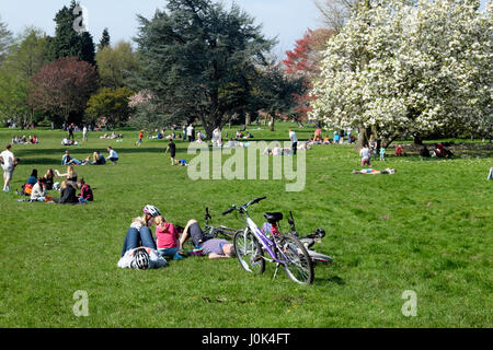 Menschen-Familie mit Fahrrädern liegend an einem sonnigen Sonntag genießen Frühlingswetter im Bute Park, Cardiff Wales UK KATHY DEWITT Stockfoto
