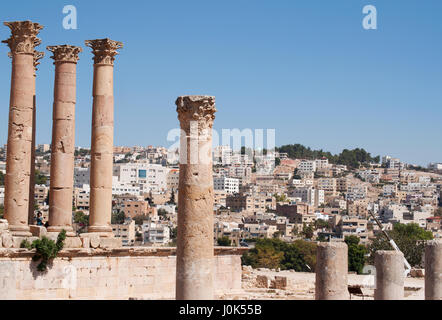 Jordanien: Korinthischen Säulen des Tempels der Artemis in die archäologische Stadt Gerasa mit der Skyline des modernen Jerash Stockfoto