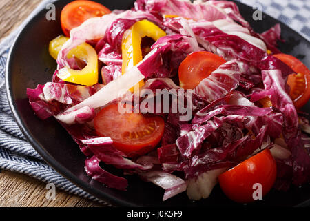 Radicchio-Salat mit Tomaten und Paprika Closeup auf einem Teller. horizontale Stockfoto