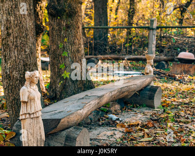 Statuen ohne Hände neben einer Holzbank im Wald Stockfoto