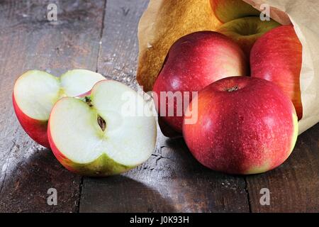 Äpfel (Sorte Elstar) in eine Papiertüte auf hölzernen Hintergrund Stockfoto