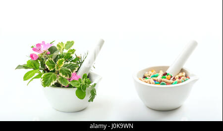 Kräuter und Pillen im Mörser isoliert auf weißem Hintergrund. Stockfoto