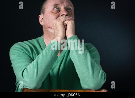 Schönes Portrait von reifer Mann in grünlich-blaue Trikot mit Hoffnung nachschlagen Stockfoto