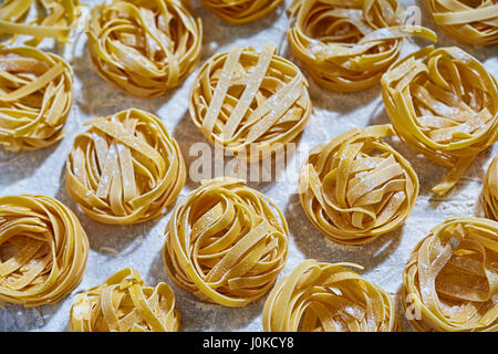 Frische Pasta mit Mehl auf weiße Oberfläche Stockfoto