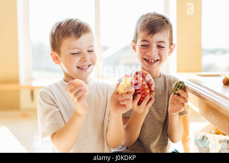 Zwei jungen mit Ostereiern und Lächeln einander Stockfoto