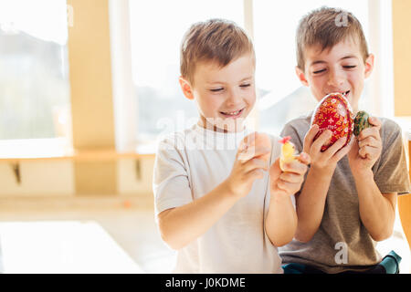 Zwei jungen mit Ostereiern und Lächeln einander Stockfoto