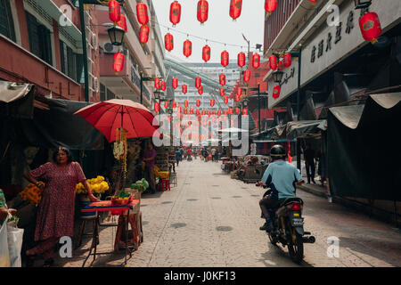 Kuala Lumpur, Malaysia - 17. März 2016: Mann mit Motorrad durch die überfüllten Petaling Street, Chinatown am 17. März 2016 in Kuala Lumpur, Malaien Stockfoto