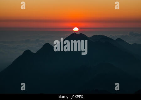 Der Sonnenuntergang über einem Berg im Himalaya, in ein Bett aus Wolken Stockfoto