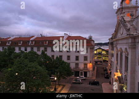 Die Kirche Paroquial de Sao Paulo in der Cais Sodre Gegend von Lissabon zusammen mit den Bäumen und Häusern auf dem Platz vor.  Im Hintergrund ist th gesehen Stockfoto