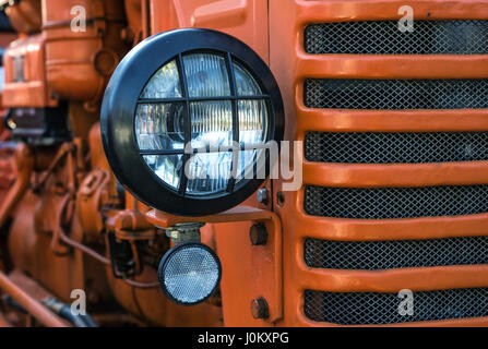 Die Scheinwerfer des verlassenen rostige Oldtimer-Traktor. Kleine Schärfentiefe. Stockfoto