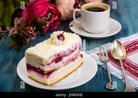 Stück Kuchen, Kuchen, Sahne, Kirschen, Schlagsahne auf blauem Hintergrund. Studio Photo Stockfoto