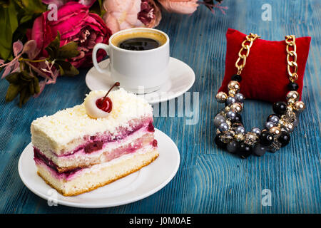 Stück Kuchen, Kuchen, Sahne, Kirschen, Schlagsahne auf blauem Hintergrund. Studio Photo Stockfoto