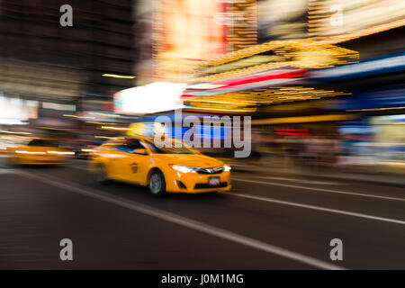 Gelbe Taxi fahren durch den Times Square bei Nacht, New York, USA Stockfoto