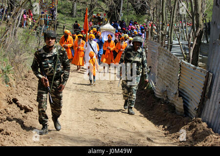 Anantnag, Indien. 14. April 2017. Indischen paramilitärischen Kräfte Begleitung eine Prozession von Sikh nachdem sie feiert Baisakhi in Chattisinghpora Anantnag einige 55 km von Srinagar Sommer Hauptstadt von Kaschmir. Das Festival hat besondere Bedeutung für Sikhs, da es der Tag im Jahre 1699, markiert als ihren zehnten Guru Gobind Singh die Reihenfolge der Khalsa, ein Kollegialorgan initiierten Sikhs organisiert. Bildnachweis: Muneeb Ul Islam/Pacific Press/Alamy Live-Nachrichten Stockfoto