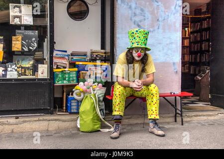 Zagreb, Kroatien - Clown sitzt vor einem antiken Buchladen Stockfoto