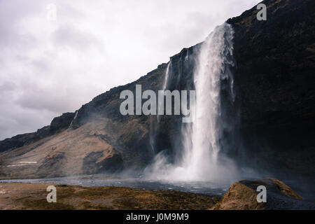 Breite Schuss Spray geworfen vom Wasserfall Seljalandsfoss, eines der beliebtesten Naturwunder im Süden Islands Stockfoto