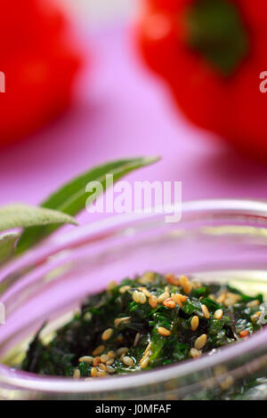 Pflanzliche grüne Dressing mit Sesam in Glasschale mit unscharfen Hintergrund Stockfoto