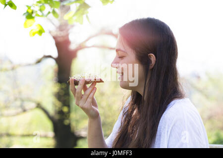 Teenager-Mädchen essen Roggenbrot mit rote-Bete-Creme und Alfalfa Sprossen Stockfoto