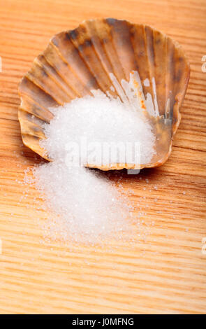 Salz in braun Jakobsmuschel auf natürliche Holzplatte Stockfoto
