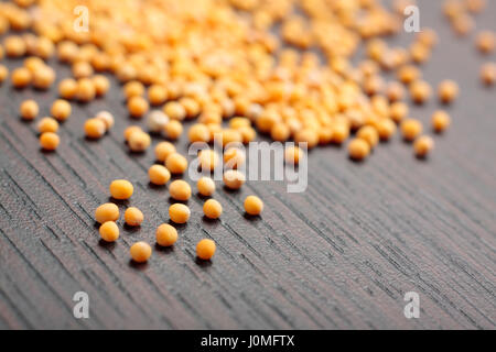Weißen Senfsamen (Sinapis Alba) auf dunklen Tisch. Nahaufnahme Foto. Stockfoto
