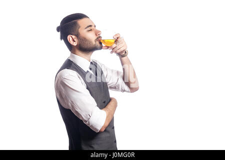 Gut aussehend bärtigen Geschäftsmann mit einem Glas Whisky. genießen und trinken mit geschlossenen Augen. Studioaufnahme, isoliert auf weißem Hintergrund. Stockfoto