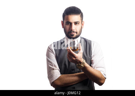 Gut aussehend bärtigen Geschäftsmann mit einem Glas Whisky. Glas und Blick in die Kamera. Studioaufnahme, isoliert auf weißem Hintergrund. Stockfoto