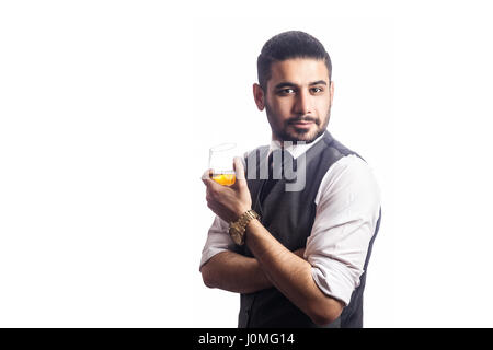 Gut aussehend bärtigen Geschäftsmann mit einem Glas Whisky. Glas und Blick in die Kamera. Studioaufnahme, isoliert auf weißem Hintergrund. Stockfoto