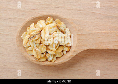 Holzlöffel gefüllt mit Haferflocken. Nahaufnahme, Ansicht von oben. Stockfoto