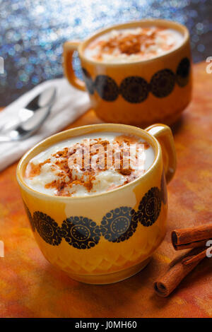 Zwei Tassen gefüllt mit Milchreis mit Zimt. Schrägen Gestell, Fokus auf erste Tasse. Stockfoto