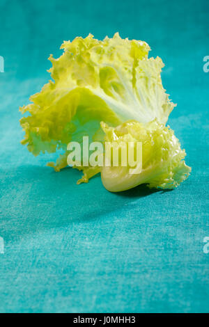 Frischen Salatblättern auf Smaragd lackiert Textile Hintergrund Stockfoto