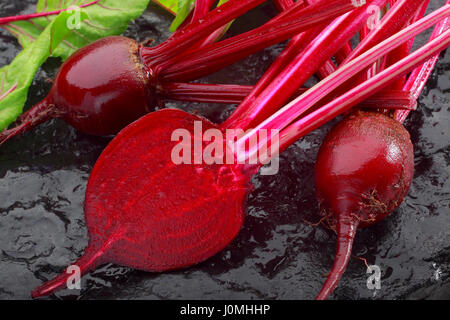 Frische rote Beete auf schwarz bemalten Stein Stockfoto