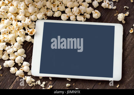 frisches Popcorn mit digital Touch-Screen-Tablette Stockfoto